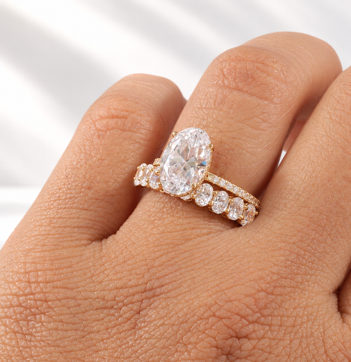 Oval cut colorless ring stone with an elongated shape and bright faceted sparkle, with a hidden halo beneath