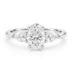 Oval cut diamond three-stone engagement ring in polished silver with two pear-shaped side diamonds and a sleek polished band.