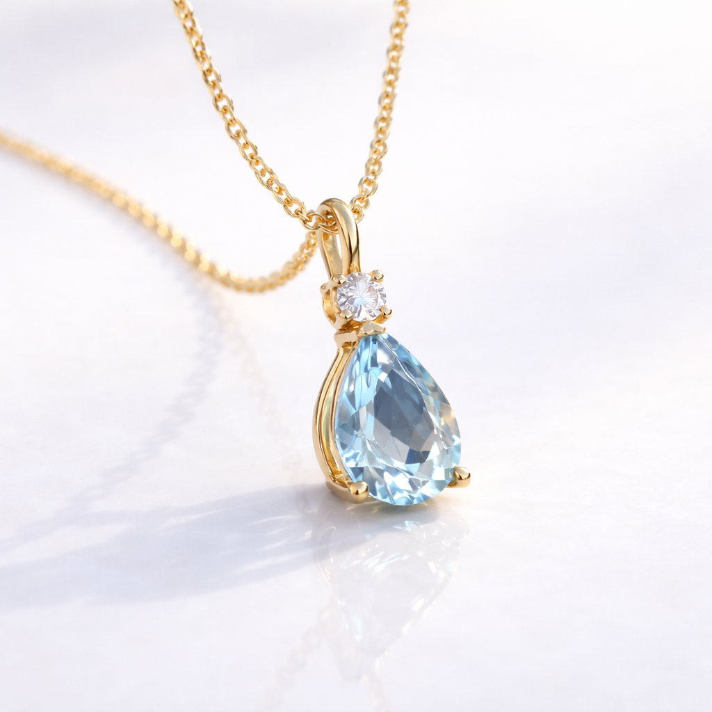 Pear-Shaped Aquamarine Pendant With Round Diamond Setting In Yellow Gold.
