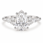 Luxury pear shaped moissanite engagement ring featuring a bright polished silver band, secure prong setting, marquise side stones, and sparkling round diamond accents for a timeless wedding ring style.