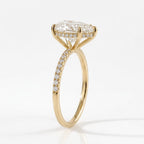 Front view of a pear cut moissanite solitaire engagement ring set in yellow gold with three prongs and a sparkling micropavé diamond band.