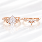 Pear cut colorless ring stone with a clear table and symmetrical teardrop shape, with small accent stones on both sides