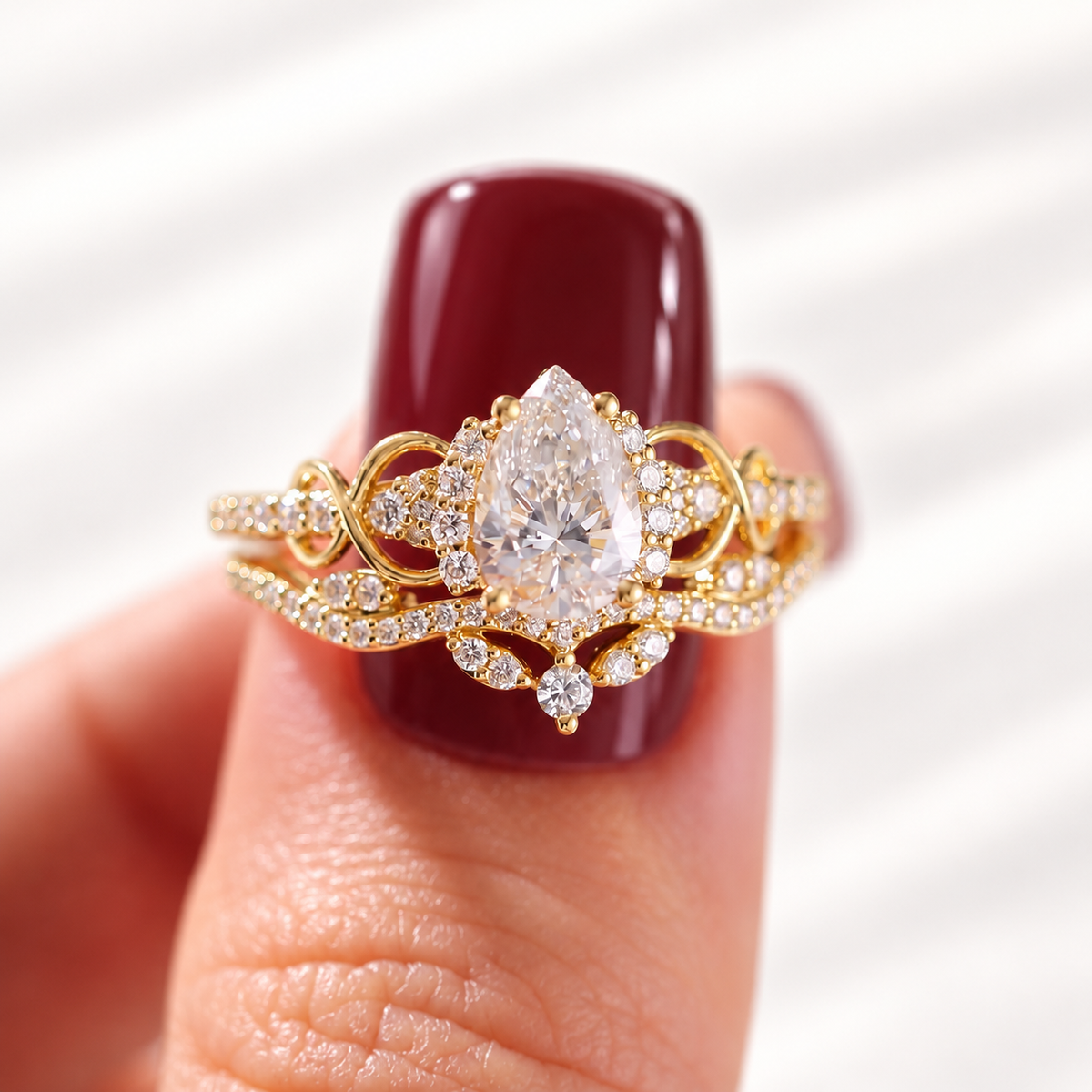 Pear cut colorless ring stone with clear brilliant facets and a pointed top, framed by a halo of small round stones