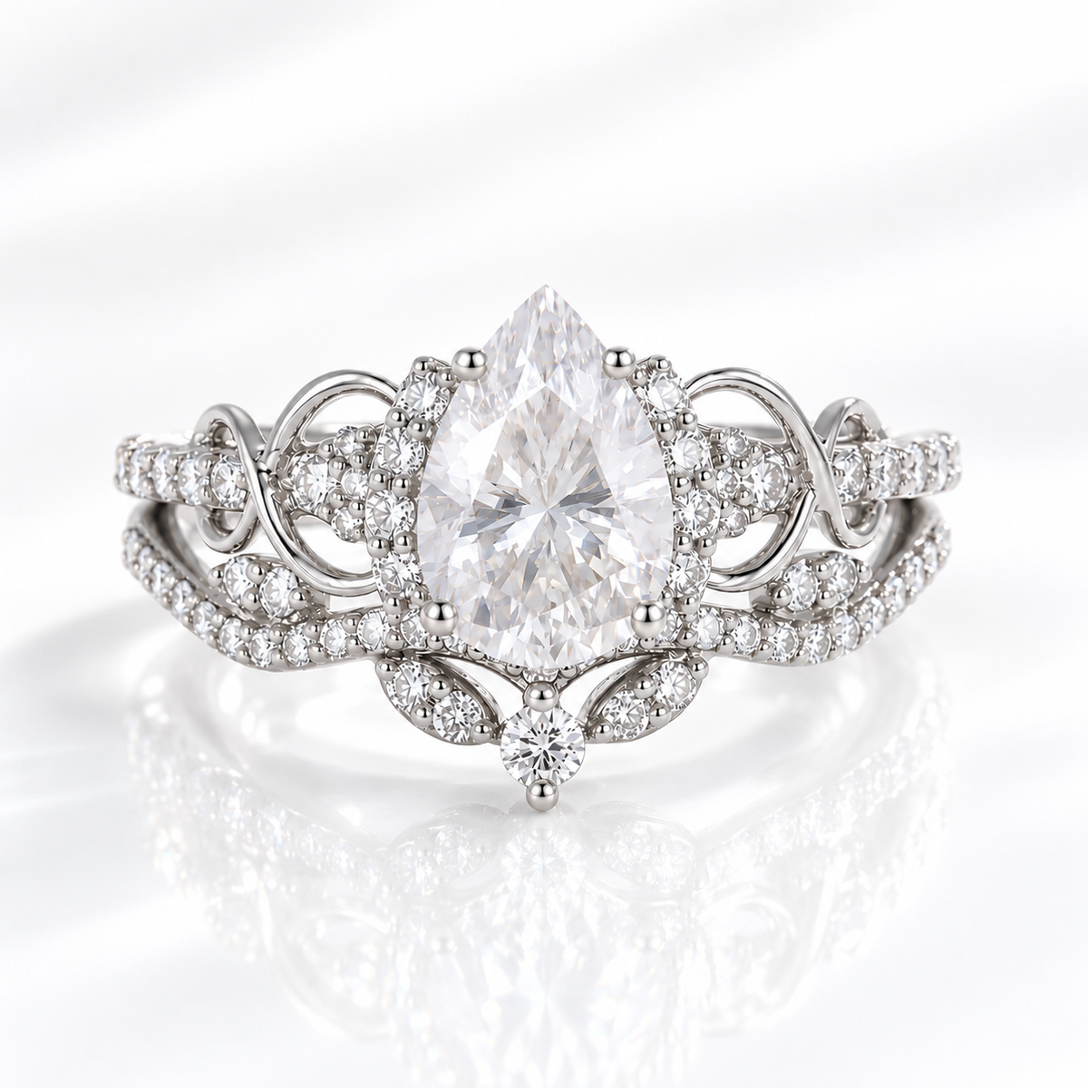 Pear cut clear ring stone with bright sparkle, held by prongs and framed by a halo of tiny round stones