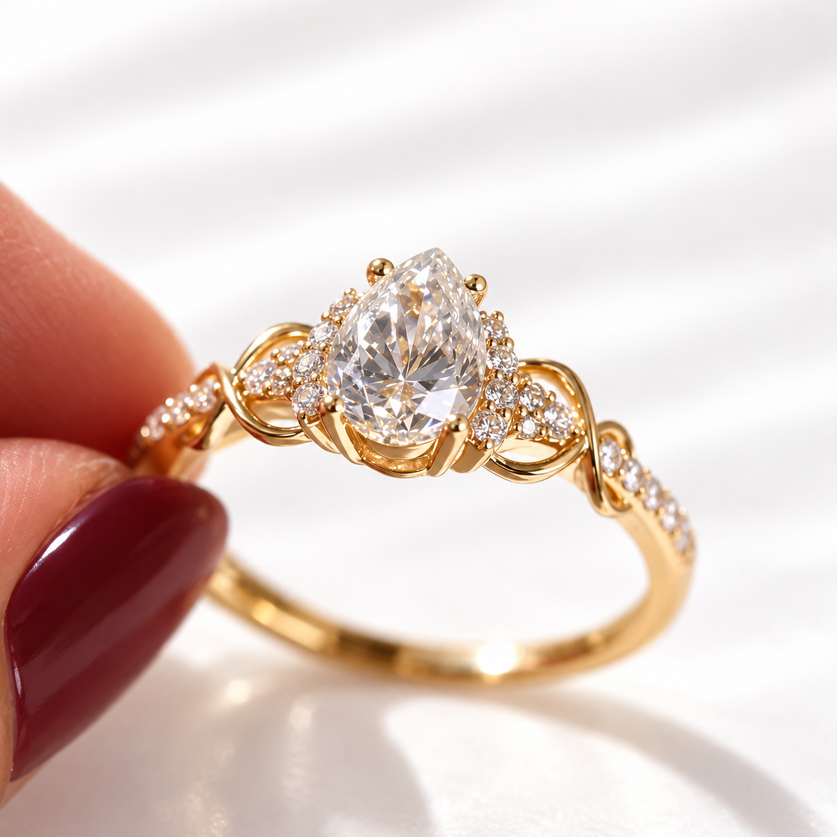 Angled view of a pear cut colorless ring stone showing its brilliant facets, prong setting, and small accent stones beside it