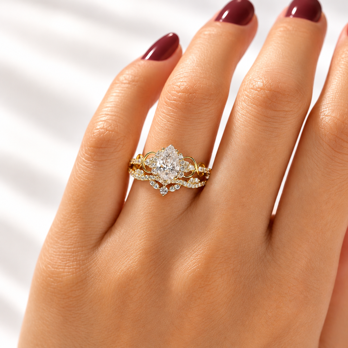 Pear cut colorless ring stone with a teardrop shape and bright faceted sparkle, surrounded by small accent stones