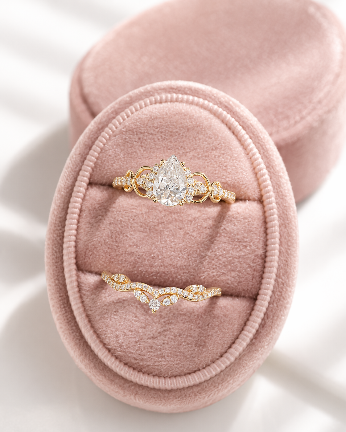 Pear cut colorless ring stone with brilliant facets and a teardrop outline, surrounded by small round accent stones