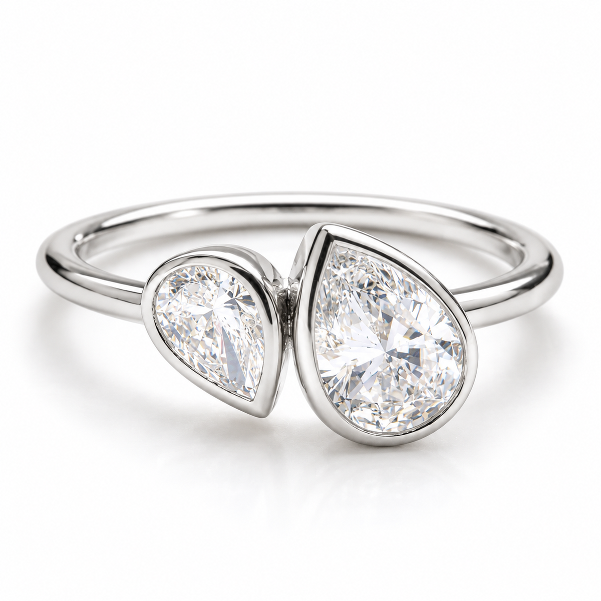 Polished silver bypass ring with two pear-shaped sparkling gemstones in bezel settings
