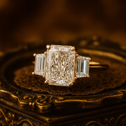 Radiant Cut Three Stone Diamond Engagement Ring In 18K Yellow Gold Featuring A Central Radiant Cut Diamond With Trapezoid Side Stones