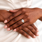 Radiant cut diamond center stone in a four-prong yellow gold setting, flanked by a cluster of round side stones on each side