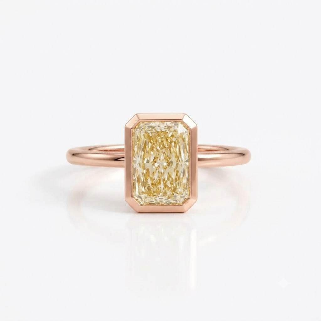 A rose gold ring featuring a rectangular emerald-cut yellow diamond center stone, set against a clean white background with a soft reflection.