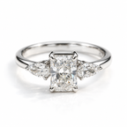 Polished silver three-stone engagement ring with rectangular center gemstone and pear-shaped side stones