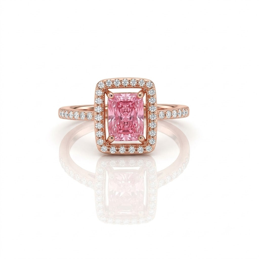 A rose gold halo ring featuring a square emerald-cut pink center stone and small pavé-set diamonds along the band, shown on a clean white background with a soft reflection below.