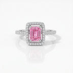 A square-cut pink gemstone ring with a halo setting and a pavé band, shown on a clean white background with a soft reflection.