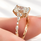 Side view of a yellow gold radiant cut diamond ring showing a hidden halo, trio cluster accents, and alternating marquise and round diamonds along the shank
