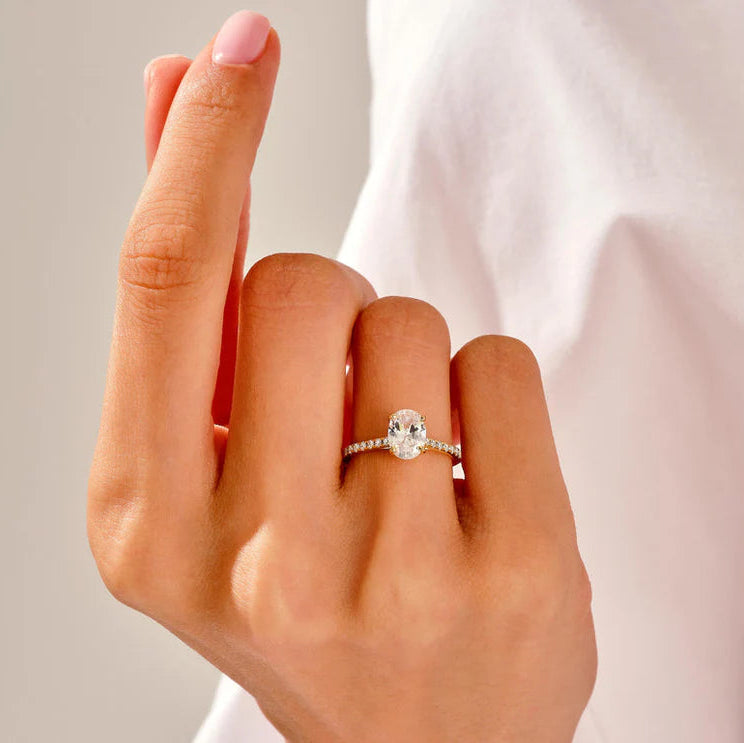 Curved wedding band paired with oval cut diamond ring
