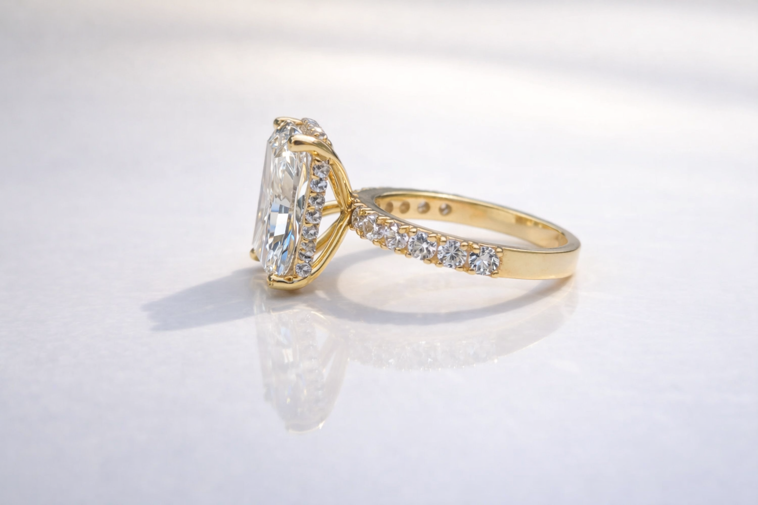 Radiant Cut Engagement Ring With 4 Round Prong Setting And Round Cut Side Stone
