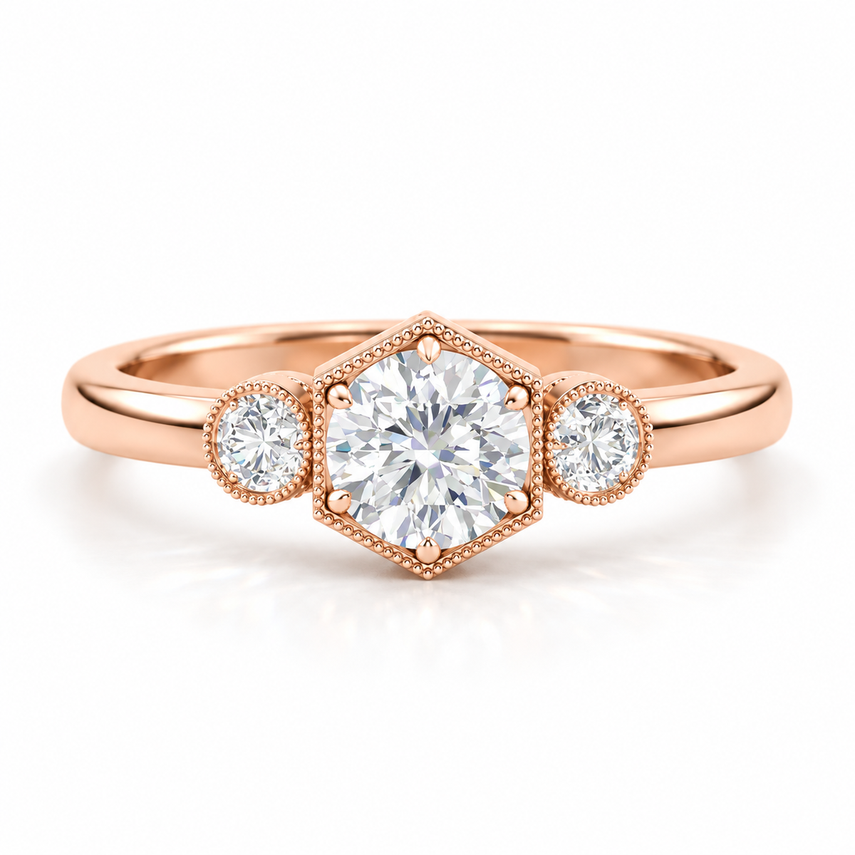 Round brilliant cut diamond three-stone engagement ring in 18K rose gold vermeil with a hexagonal milgrain setting and two round side diamonds.
