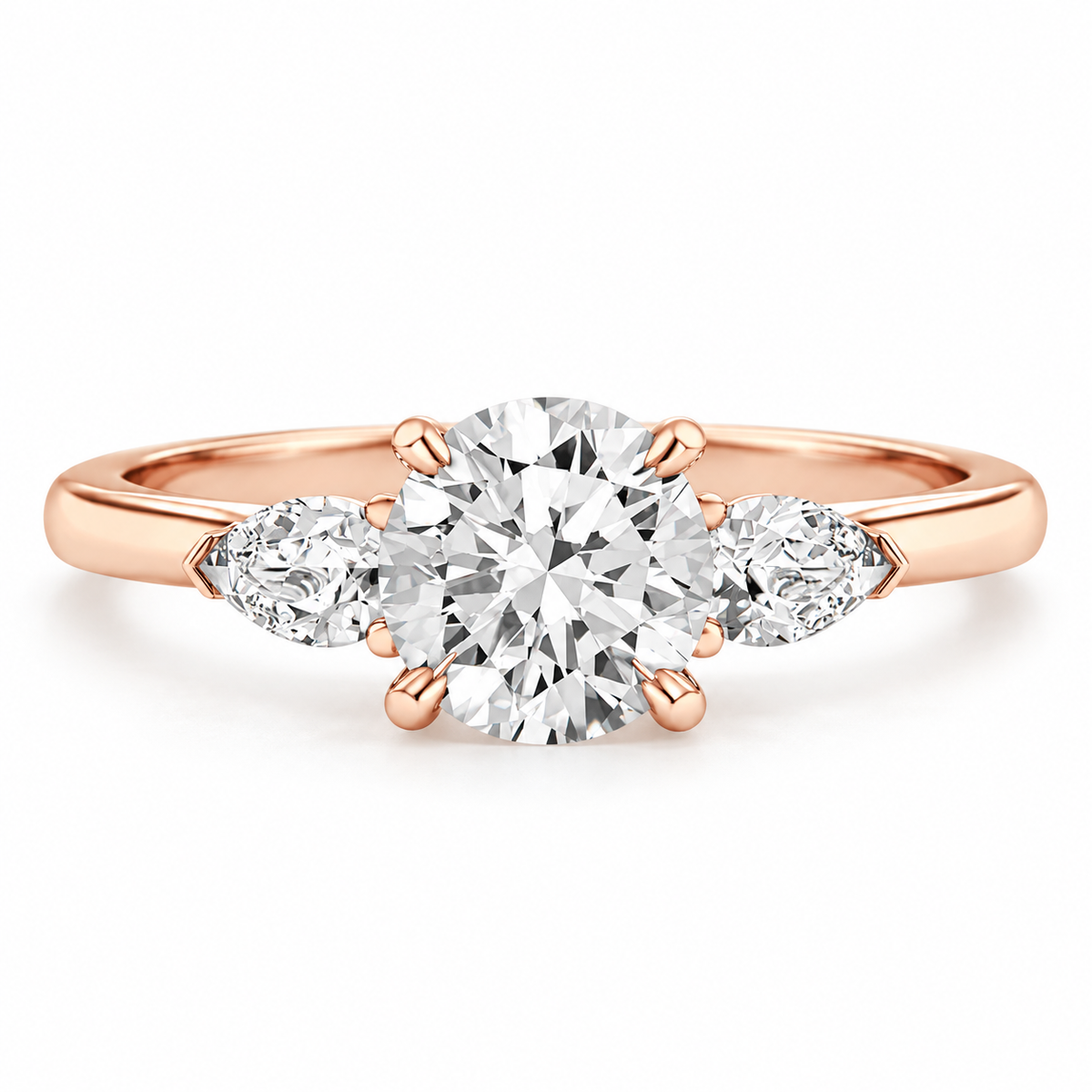 Three-stone round brilliant diamond engagement ring in 18K rose gold vermeil with a large center diamond and two pear-shaped side diamonds on a polished band.