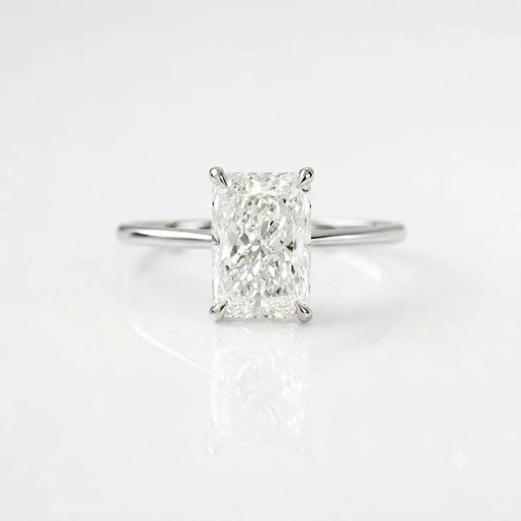 High-quality, ultra-realistic product photograph of a solitaire engagement ring featuring a large, radiant-cut center diamond held by four prongs. The ring has a simple, polished silver band. It is positioned in a balanced, lying position on a clean pure white background with soft studio lighting and subtle natural shadows. The reflection of the ring and diamond is visible on the surface.