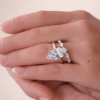 Close-up of a hand wearing a diamond ring on a light background