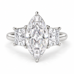 Marquise cut diamond three-stone engagement ring in polished silver with two rectangular side diamonds and a classic prong setting.