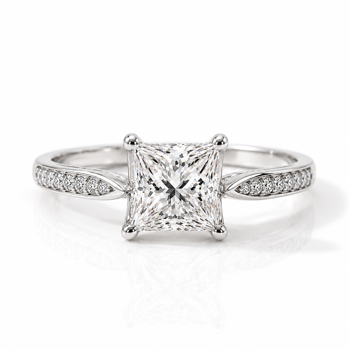 Silver princess-cut engagement ring with pavé diamond band on a white background.