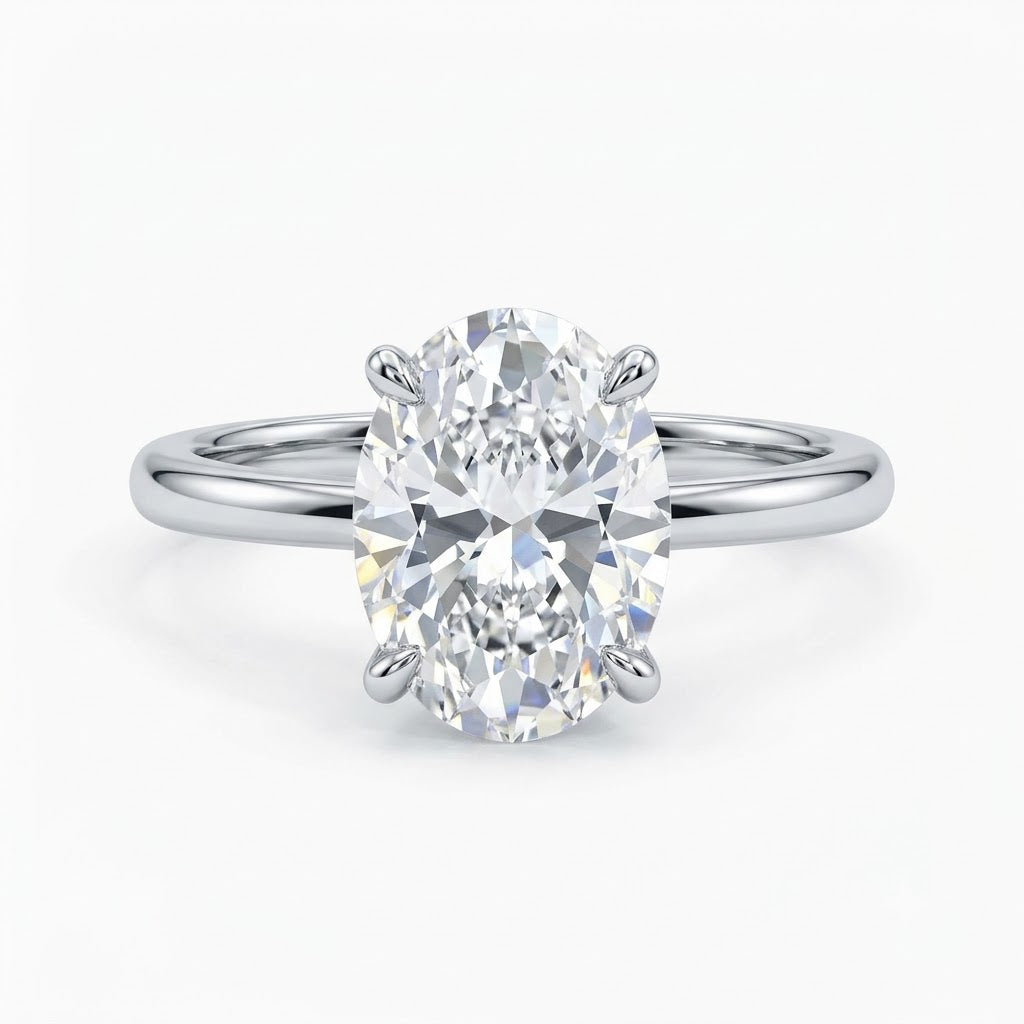 A polished silver solitaire engagement ring featuring a large oval-cut diamond secured in a four-prong setting, displayed on a clean white background.