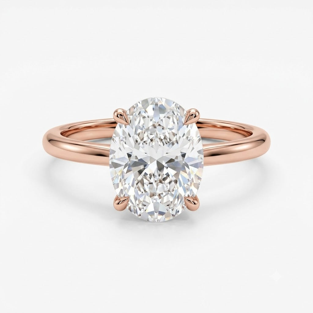 Studio product photograph of an elegant rose gold solitaire ring with a slender, polished band. The centerpiece is a prominent, brilliantly faceted oval-cut diamond held vertically by four prongs, set against a seamless white background with soft, natural shadowing.
