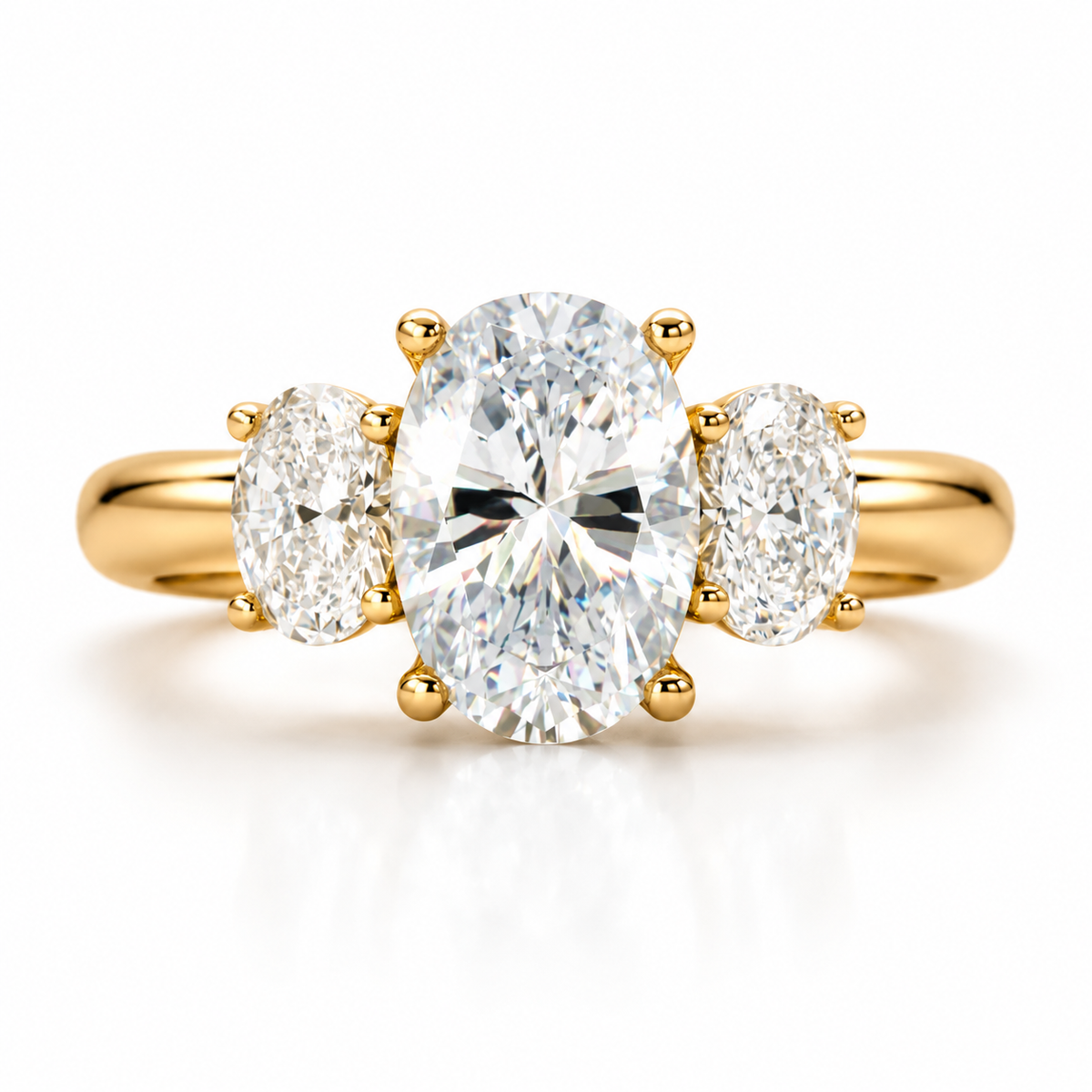 18K gold three stone engagement ring featuring a large oval center diamond with matching oval side diamonds, polished gold band, classic three-stone setting, and elegant luxury fine jewelry design on a white background.