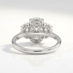 Three-stone oval cut diamond engagement ring set in white gold with matching oval side stones and a polished plain band, worn on a hand.