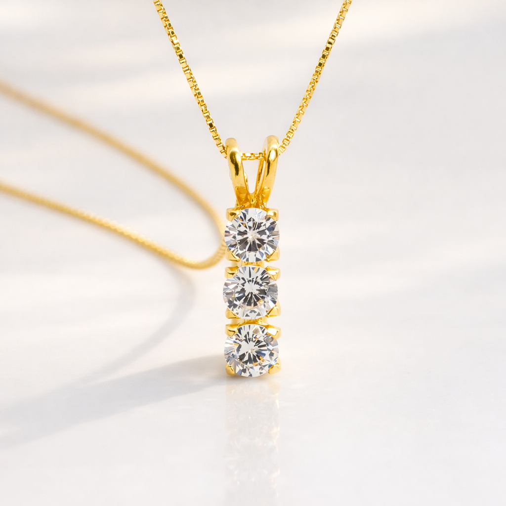 Three-Stone Round Diamond Pendant In Gold With A Modern Vertical Setting.
