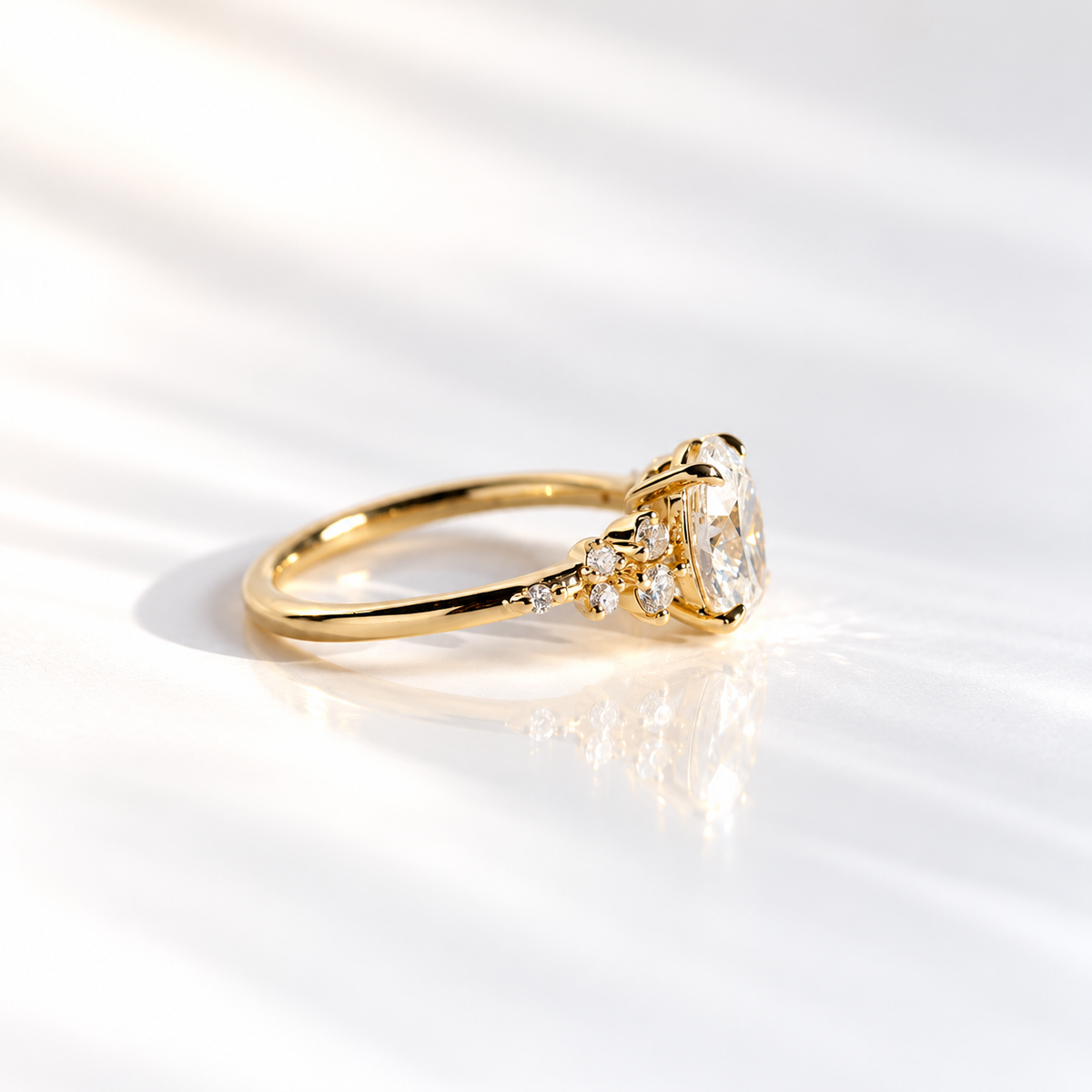 Side view of a yellow gold oval diamond engagement ring showing a thin band and cluster-set round diamonds along the shoulder