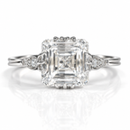 Silver Asscher-cut engagement ring with vintage leaf-inspired side details and accent diamonds.